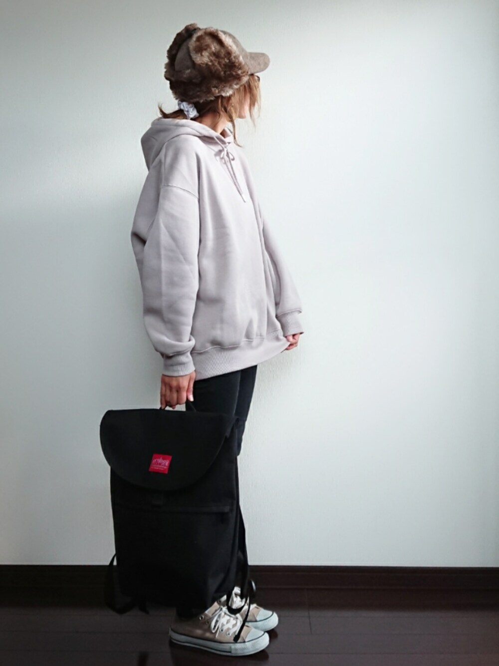 ベージュ系のパーカー、ブラック系のバックパック/リュック、ブラック系のパンツを着用したレディースの秋コーディネートの1枚目の写真