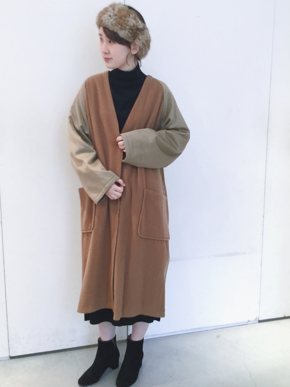 ベージュ系のダウンジャケット/コート、ブラック系のワンピース、ブラウン系のヘアバンドを着用したレディースの秋コーディネートの1枚目の写真