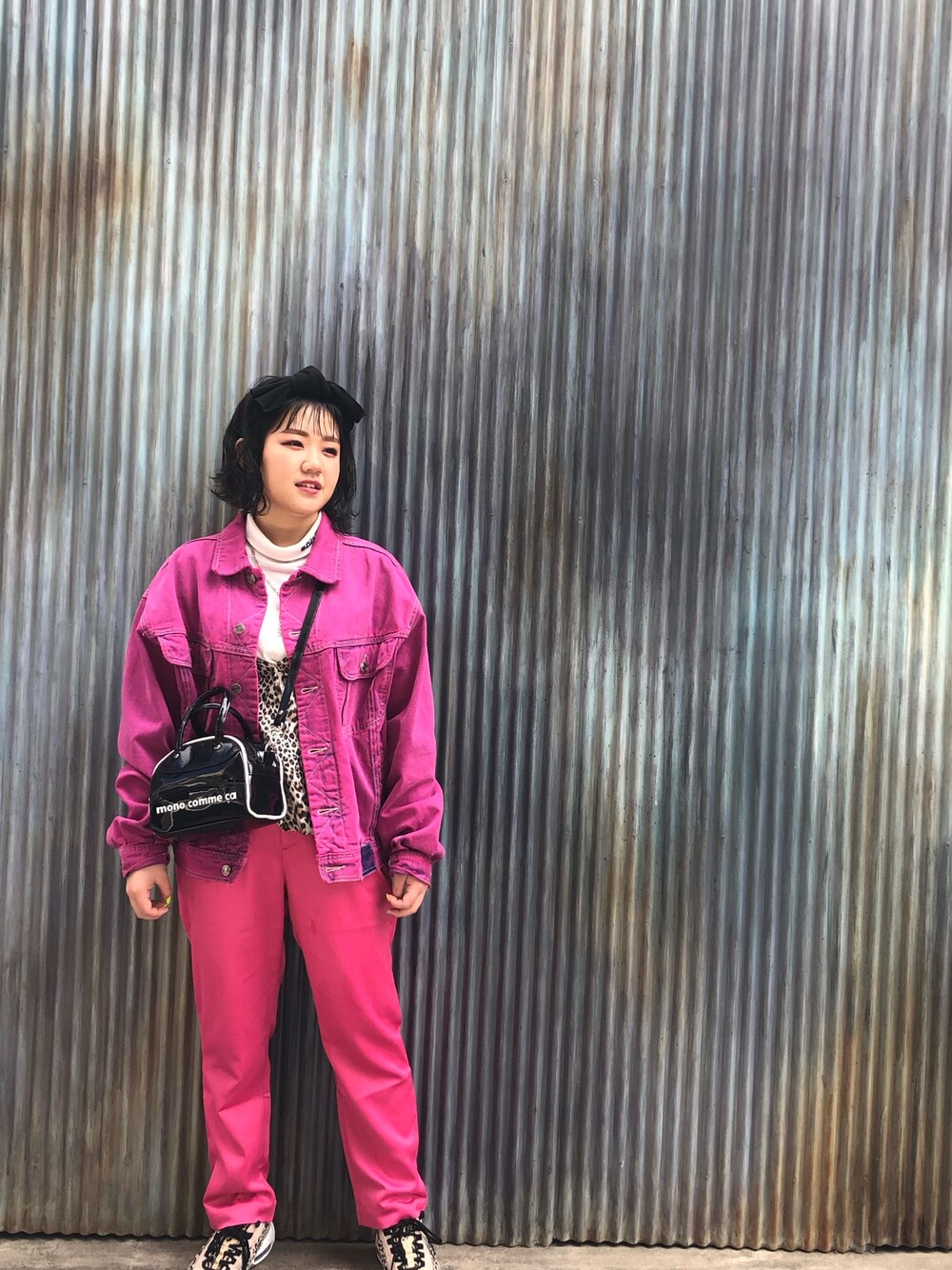 ピンク系のデニムジャケット、ピンク系のパンツ、ホワイト系のニット/セーターを着用したレディースの春コーディネートの1枚目の写真