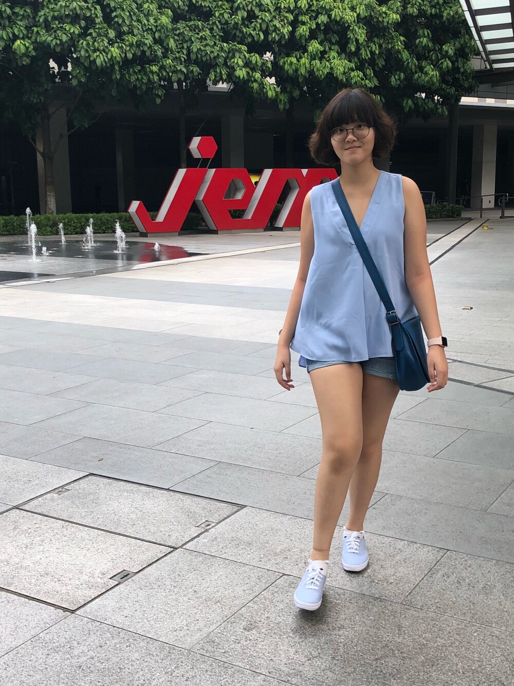 ブルー系のタンクトップ、ブルー系のデニムパンツ、ブルー系のスニーカーを着用したレディースの春コーディネートの1枚目の写真