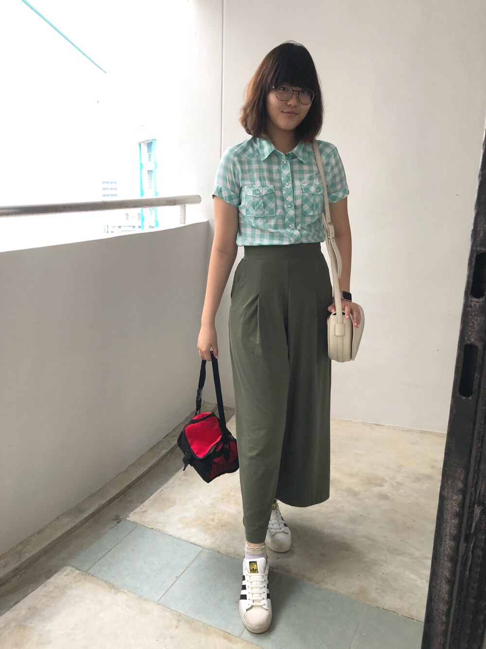 グリーン系のシャツ/ブラウス、グリーン系のその他パンツ、ベージュ系のショルダーバッグを着用したレディースの秋コーディネートの1枚目の写真