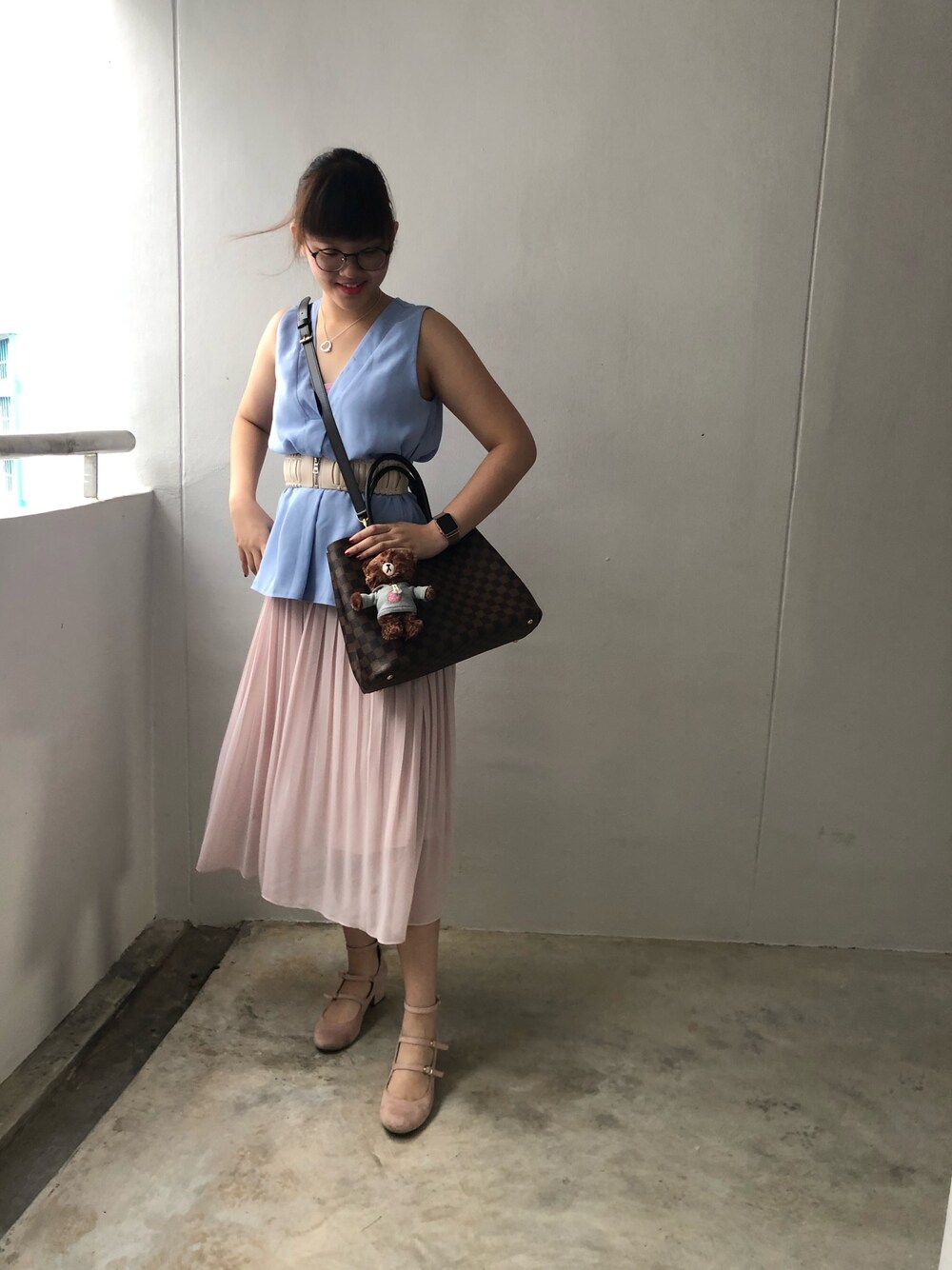 ブルー系のタンクトップ、ピンク系のスカート、ピンク系のパンプスを着用したレディースの冬コーディネートの1枚目の写真