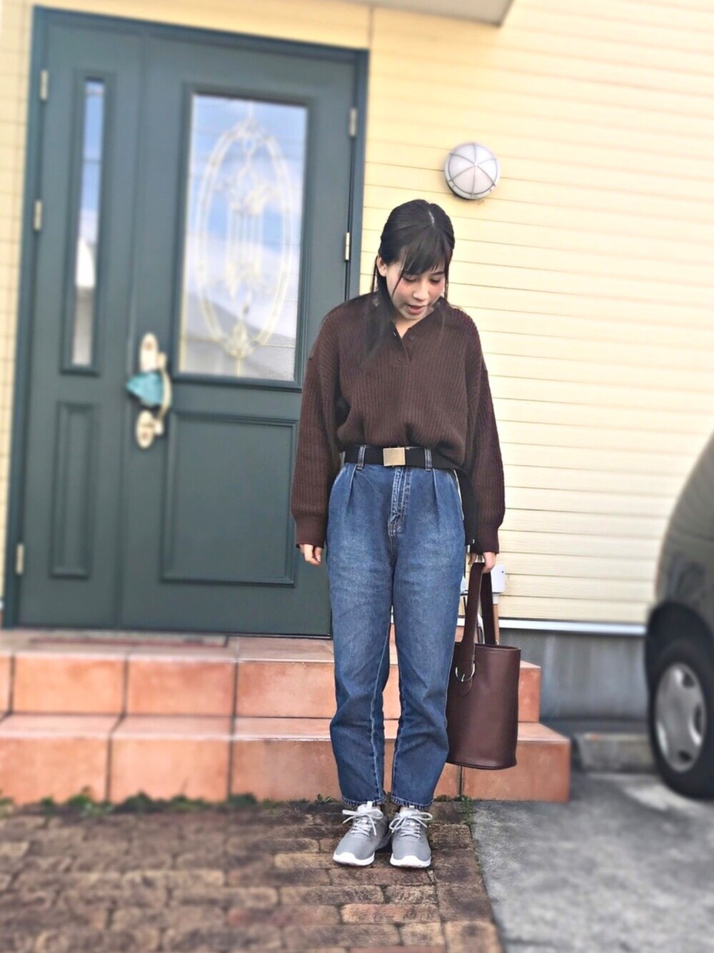 ブラウン系のニット/セーター、ブルー系のパンツ、ブラウン系のバックパック/リュックを着用したレディースの冬コーディネートの1枚目の写真