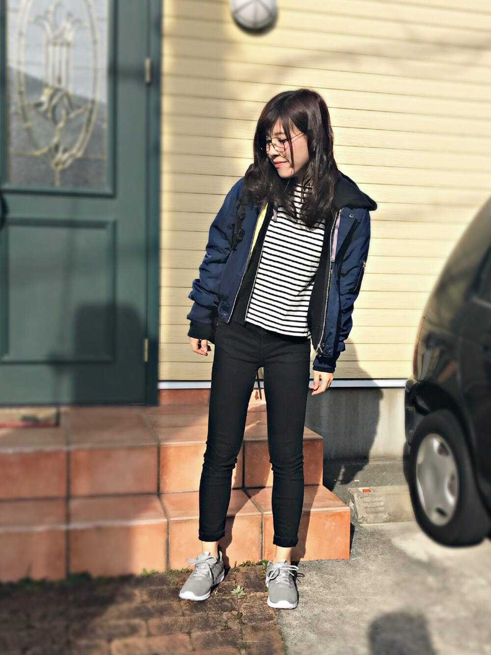 ブルー系のブルゾン、ブラック系のトップス、ホワイト系のTシャツ/カットソーを着用したレディースの冬コーディネートの1枚目の写真