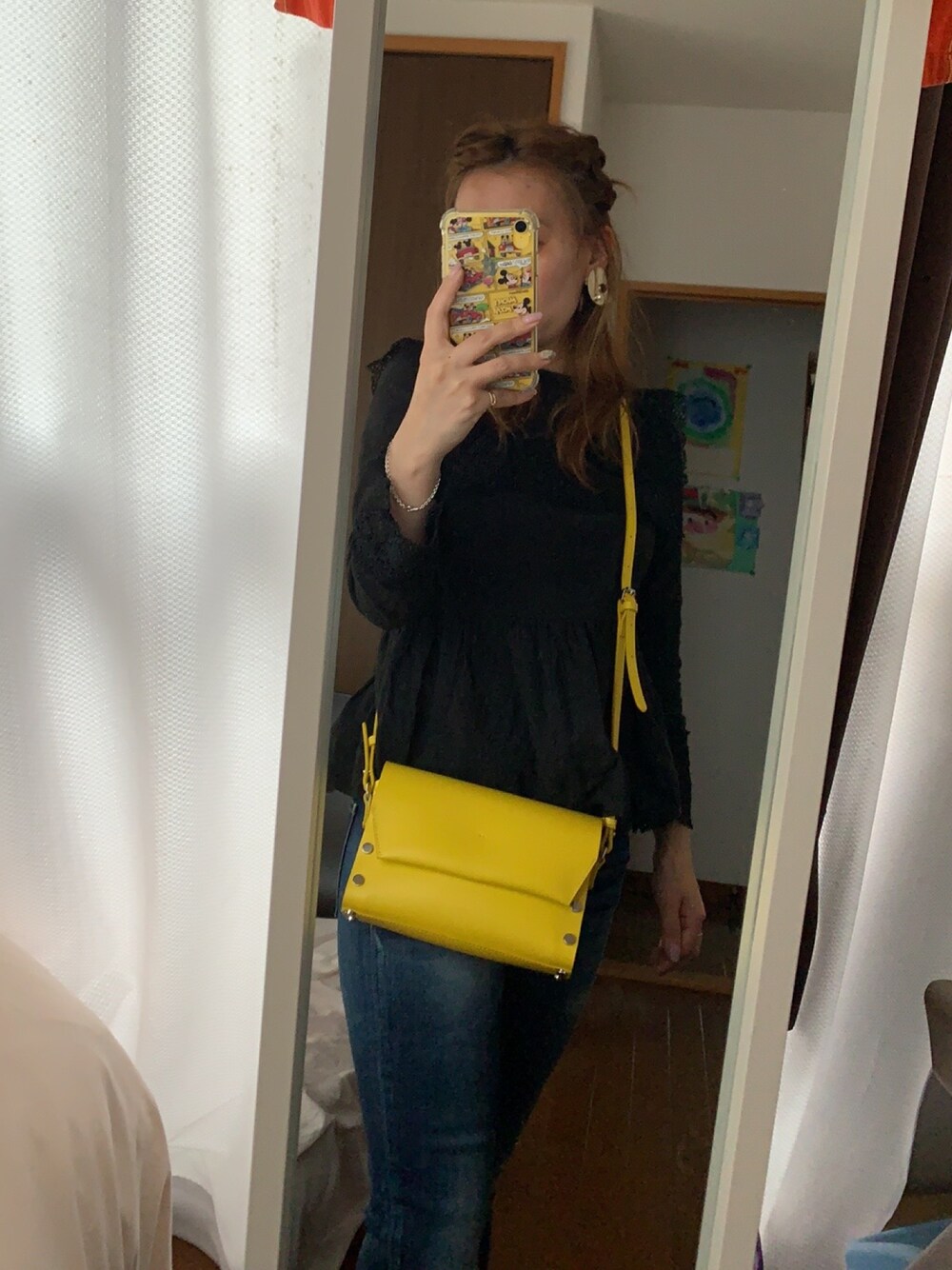 ブラック系のシャツ/ブラウス、イエロー系のショルダーバッグ、ブルー系のデニムパンツを着用したレディースの春コーディネートの1枚目の写真