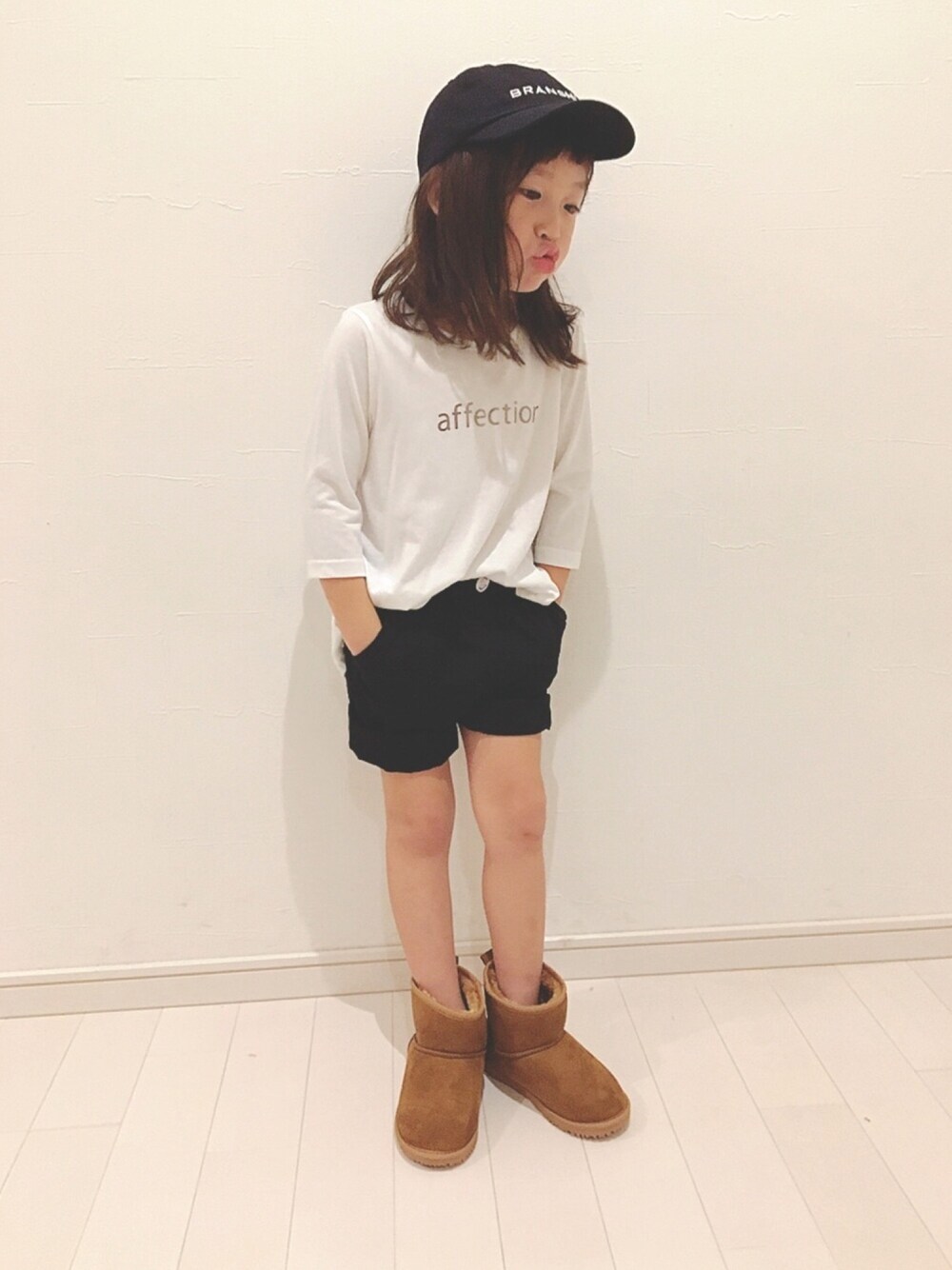 ホワイト系のTシャツ/カットソー、ブラック系のその他パンツ、イエロー系のブーツを着用したキッズの秋コーディネートの1枚目の写真
