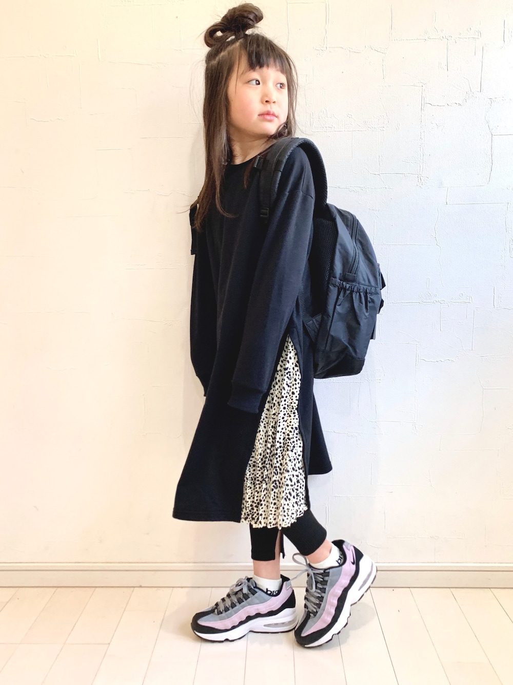 ブラック系のワンピース、ブラック系のバックパック/リュック、ブラック系のスニーカーを着用したキッズの冬コーディネートの1枚目の写真