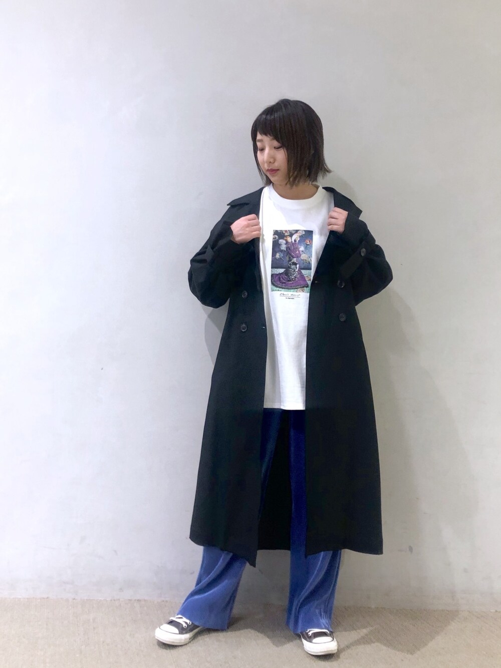ブラック系のトレンチコート、ホワイト系のTシャツ/カットソー、ブルー系のその他パンツを着用したレディースの冬コーディネートの1枚目の写真
