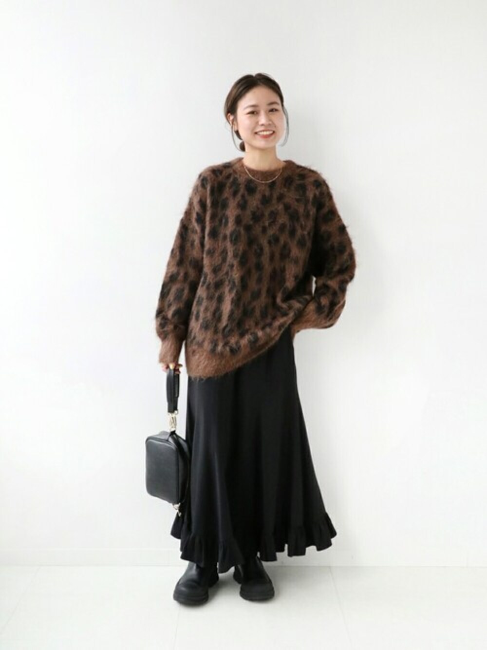 ブラウン系のニット/セーター、ゴールド系のネックレスを着用したレディースの秋コーディネートの1枚目の写真