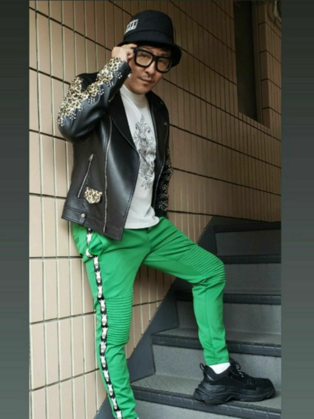 ブラック系のスニーカー、ブラック系のライダースジャケット、ホワイト系のTシャツ/カットソーを着用したメンズの秋コーディネートの1枚目の写真