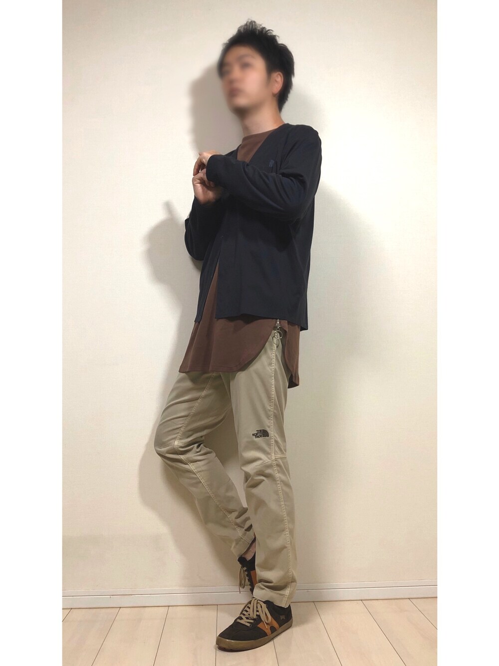 ブラック系のカーディガン/ボレロ、ブラウン系のTシャツ/カットソー、ブラウン系のスニーカーを着用したメンズの春コーディネートの1枚目の写真