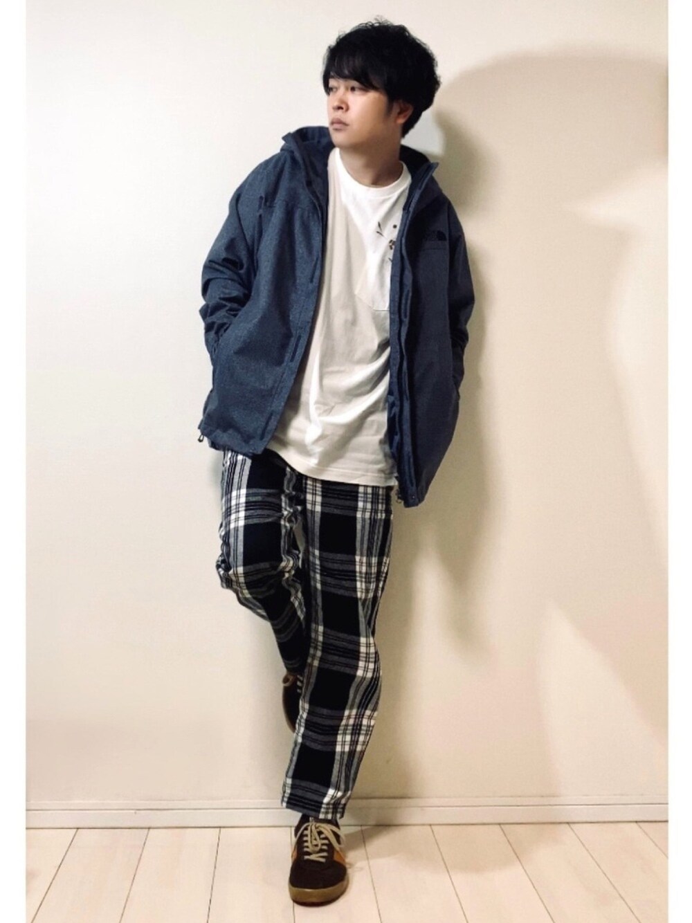 ブルー系のマウンテンパーカー、ホワイト系のTシャツ/カットソー、その他のパンツを着用したメンズの秋コーディネートの1枚目の写真