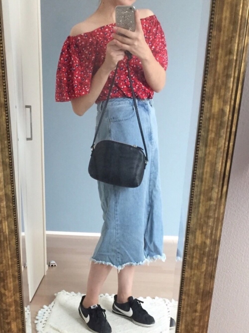 ブルー系のデニムスカート、レッド系のTシャツ/カットソー、ブラック系のスニーカーを着用したレディースの夏コーディネートの1枚目の写真