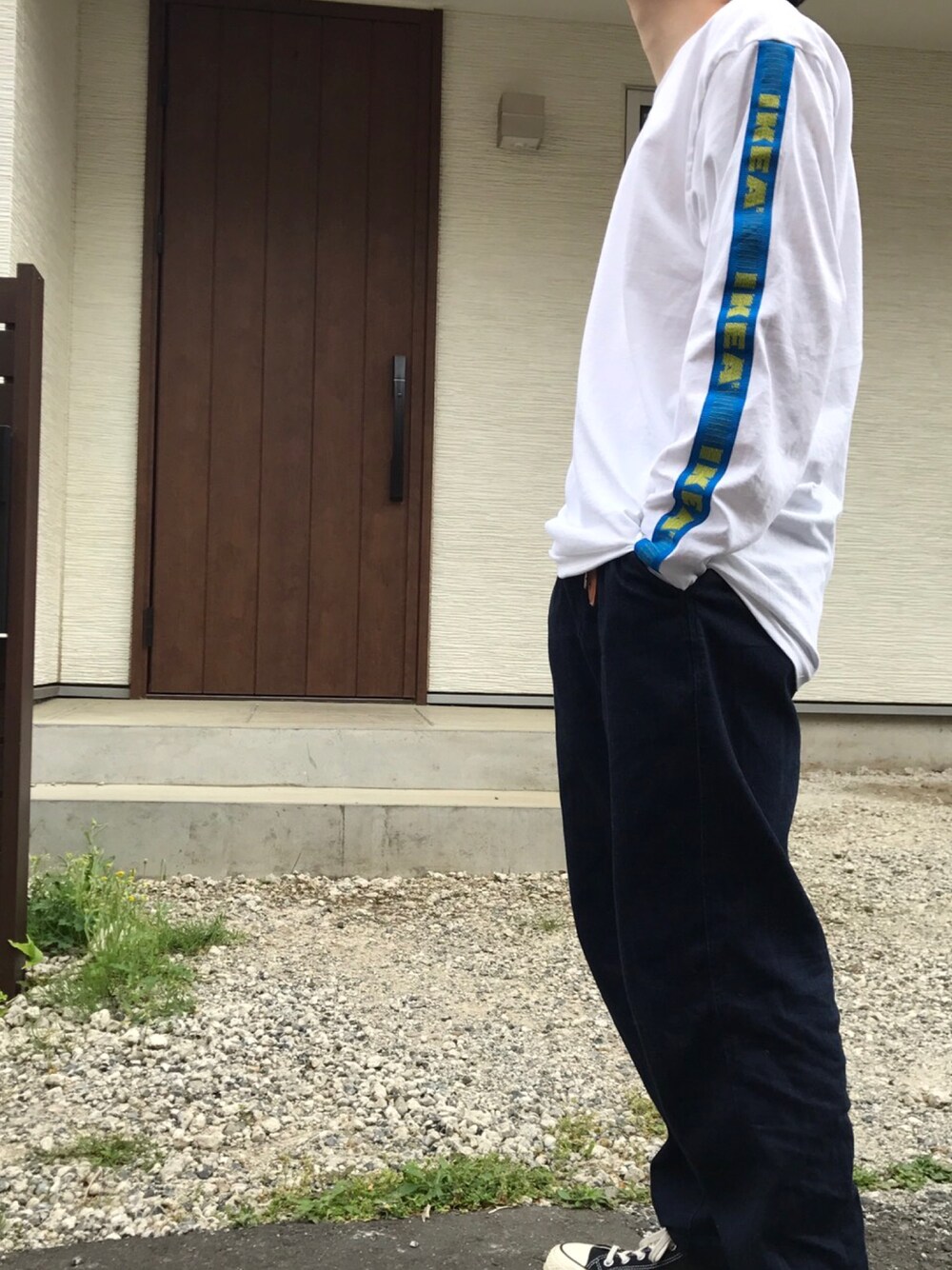 ホワイト系のTシャツ/カットソー、ブルー系のデニムパンツ、ブラック系のスニーカーを着用したメンズの春コーディネートの1枚目の写真