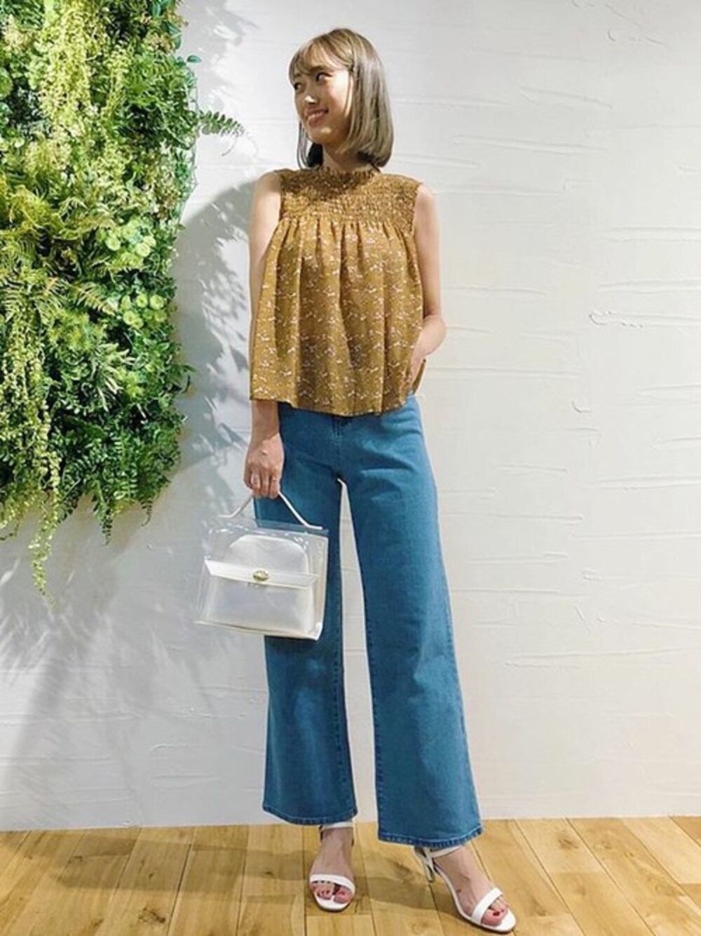 イエロー系のシャツ/ブラウス、ブルー系のデニムパンツ、ホワイト系のハンドバッグを着用したレディースの夏コーディネートの1枚目の写真