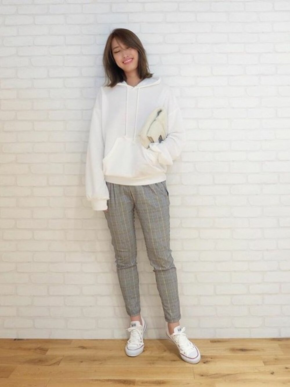 ホワイト系のパーカー、イエロー系のその他パンツ、ホワイト系のスニーカーを着用したレディースの秋コーディネートの1枚目の写真