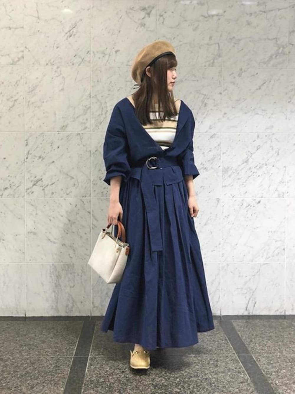 ブルー系のシャツ/ブラウス、ブルー系のスカート、ベージュ系のニット/セーターを着用したレディースの春コーディネートの1枚目の写真