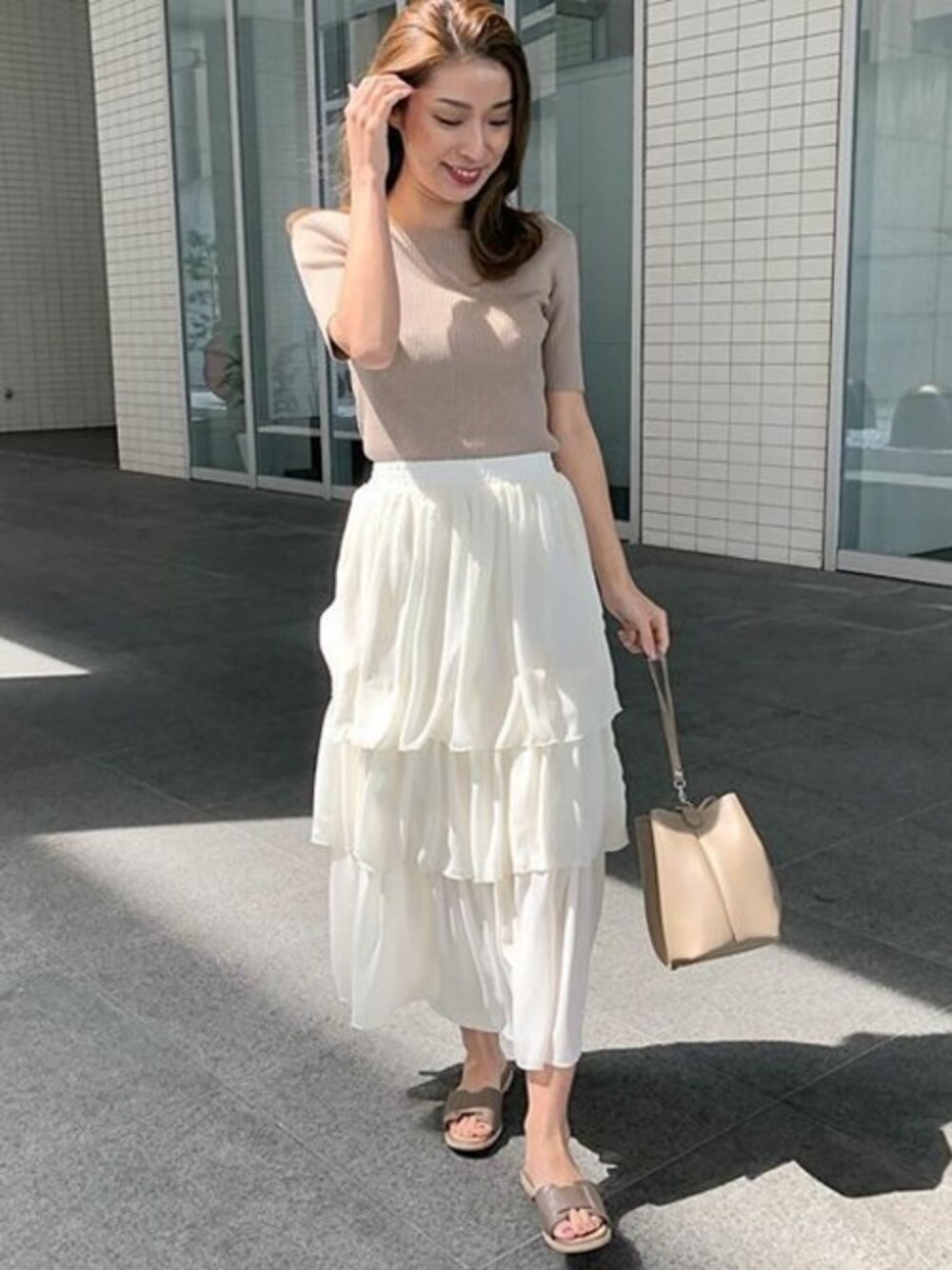 ベージュ系のハンドバッグを着用したレディースの春コーディネートの1枚目の写真