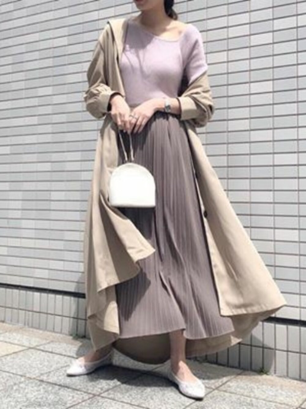 ベージュ系のトレンチコート、ピンク系のニット/セーター、ブラウン系のスカートを着用したレディースの春コーディネートの1枚目の写真