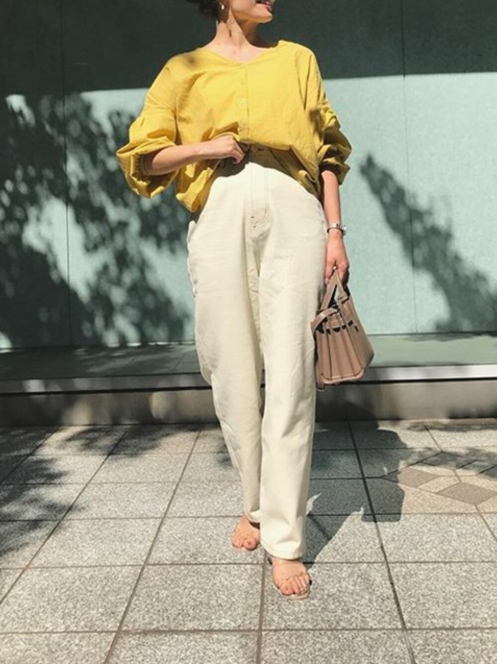 ホワイト系のデニムパンツ、イエロー系のシャツ/ブラウス、シルバー系のサンダルを着用したレディースの春コーディネートの1枚目の写真