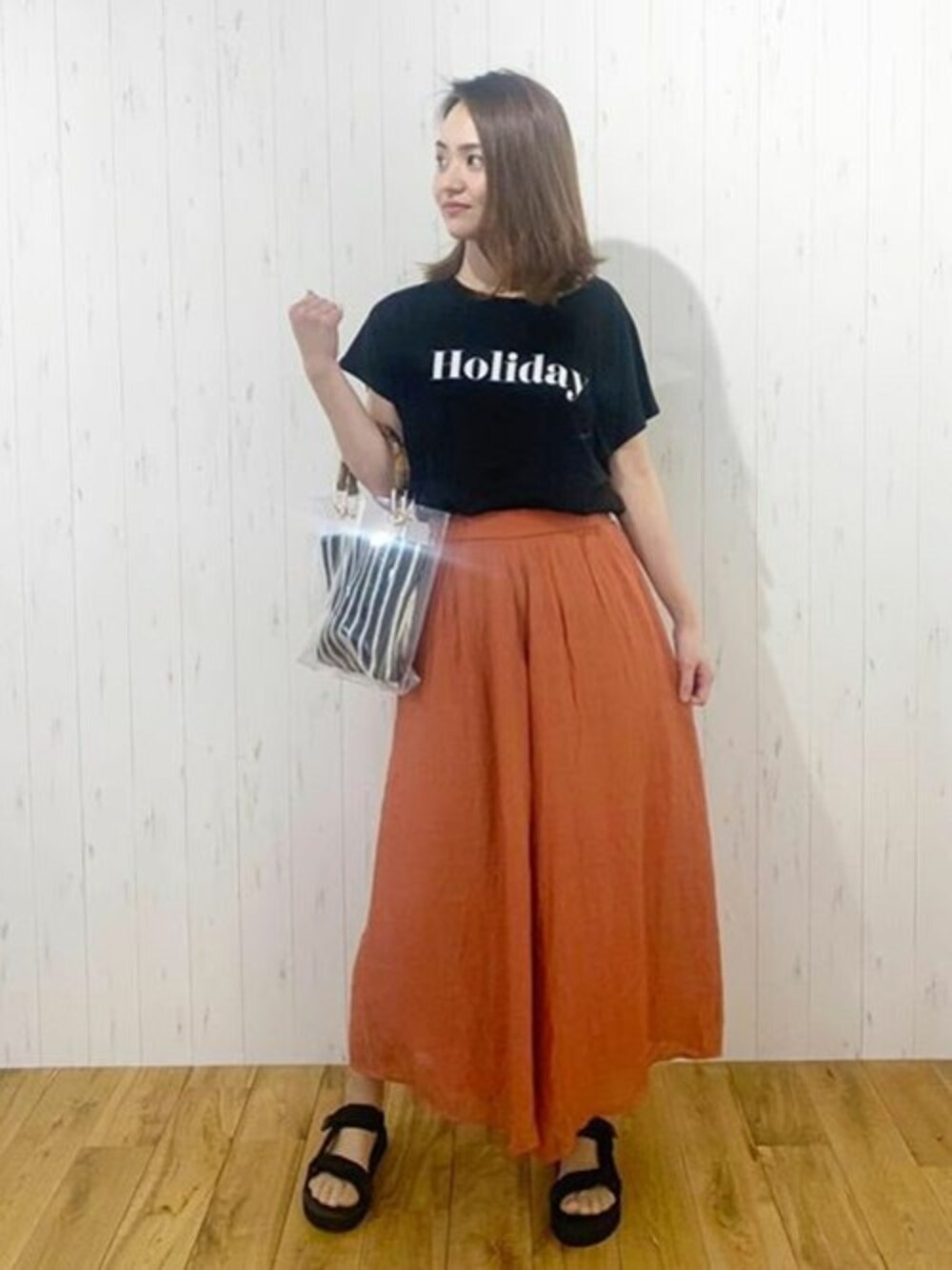 ブラック系のTシャツ/カットソー、オレンジ系のその他パンツ、ブラック系のサンダルを着用したレディースの春コーディネートの1枚目の写真