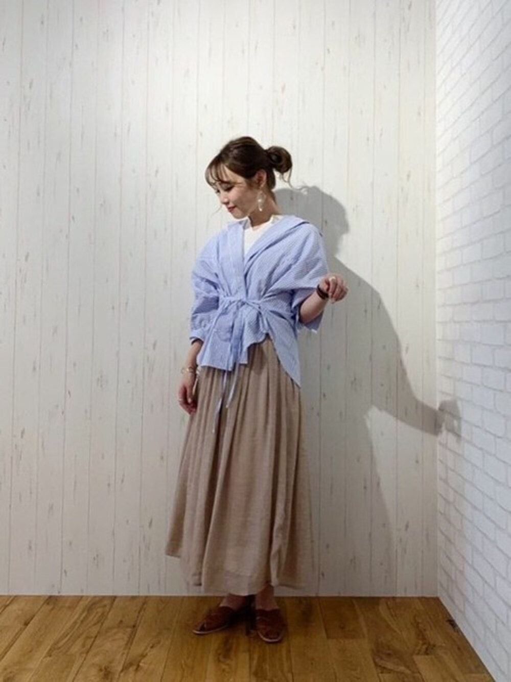 ブルー系のシャツ/ブラウス、ベージュ系のスカート、ホワイト系のワンピースを着用したレディースの春コーディネートの1枚目の写真