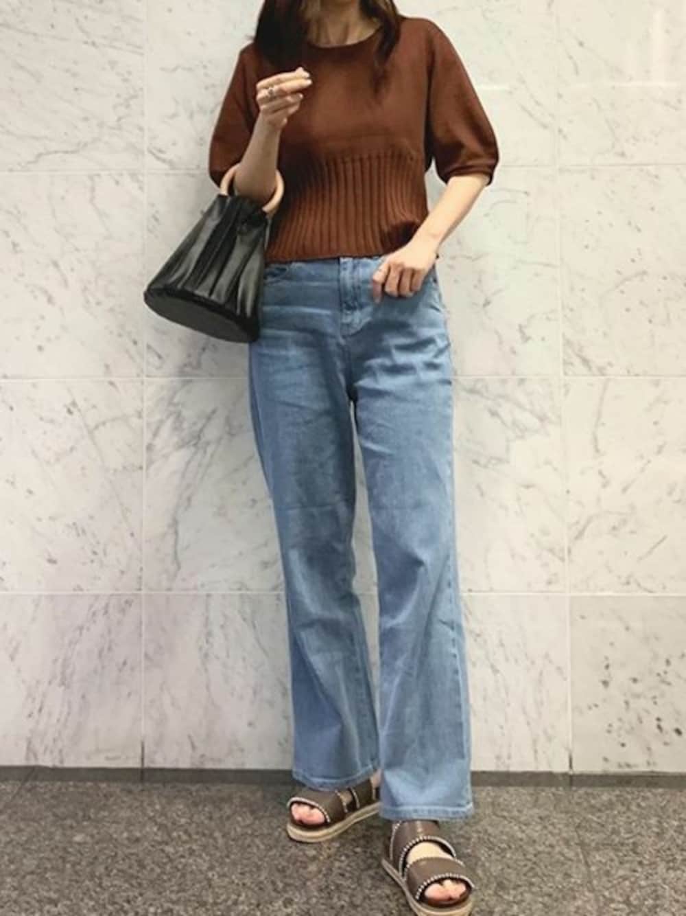 ブラウン系のニット/セーター、ブルー系のデニムパンツ、ブラウン系のサンダルを着用したレディースの夏コーディネートの1枚目の写真