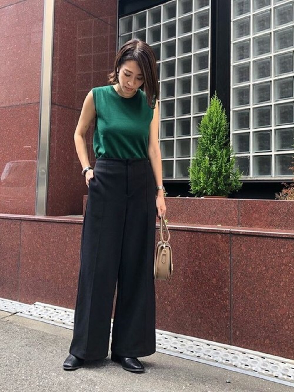 グリーン系のニット/セーター、ブラック系のその他パンツ、ブラック系のブーツを着用したレディースの秋コーディネートの1枚目の写真