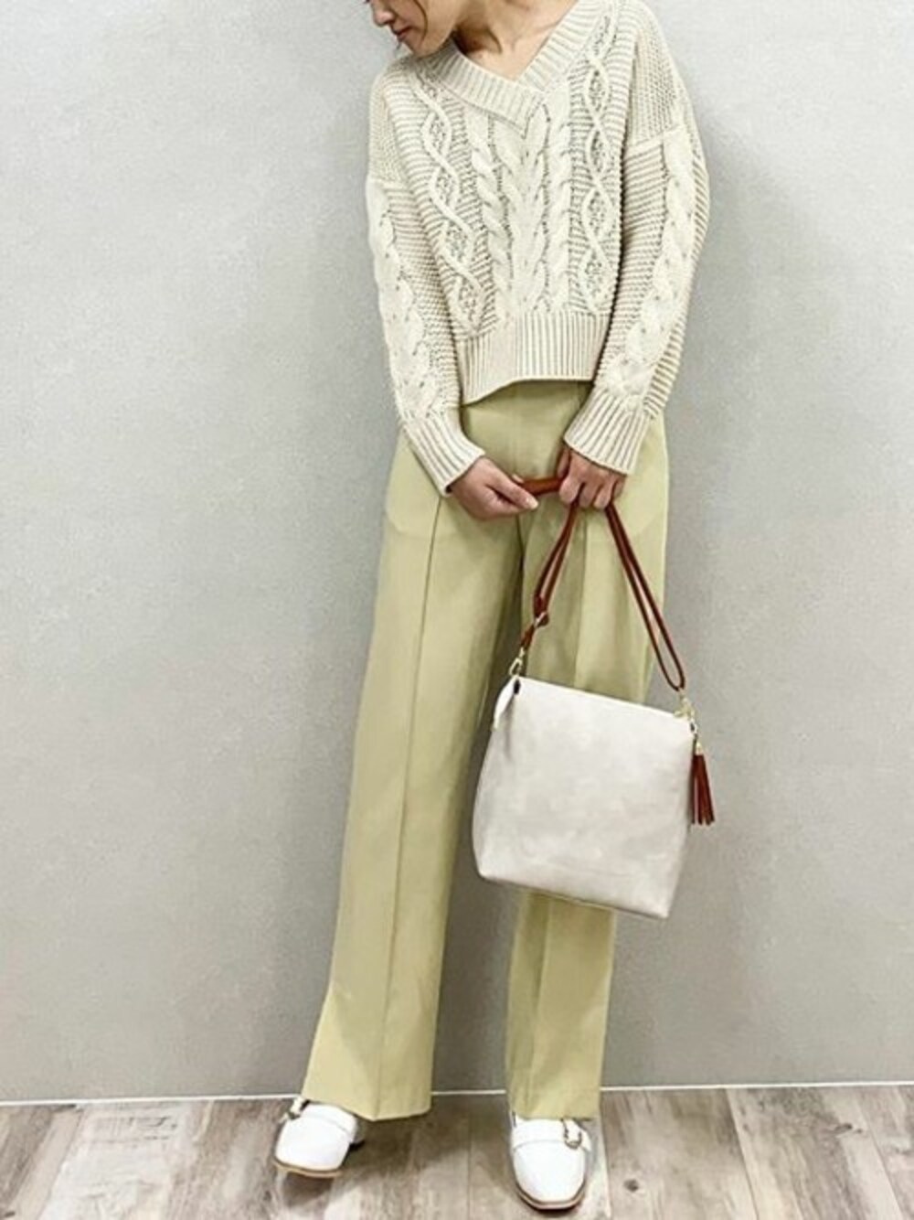 ベージュ系のニット/セーター、イエロー系のその他パンツ、ホワイト系のローファーを着用したレディースの冬コーディネートの1枚目の写真