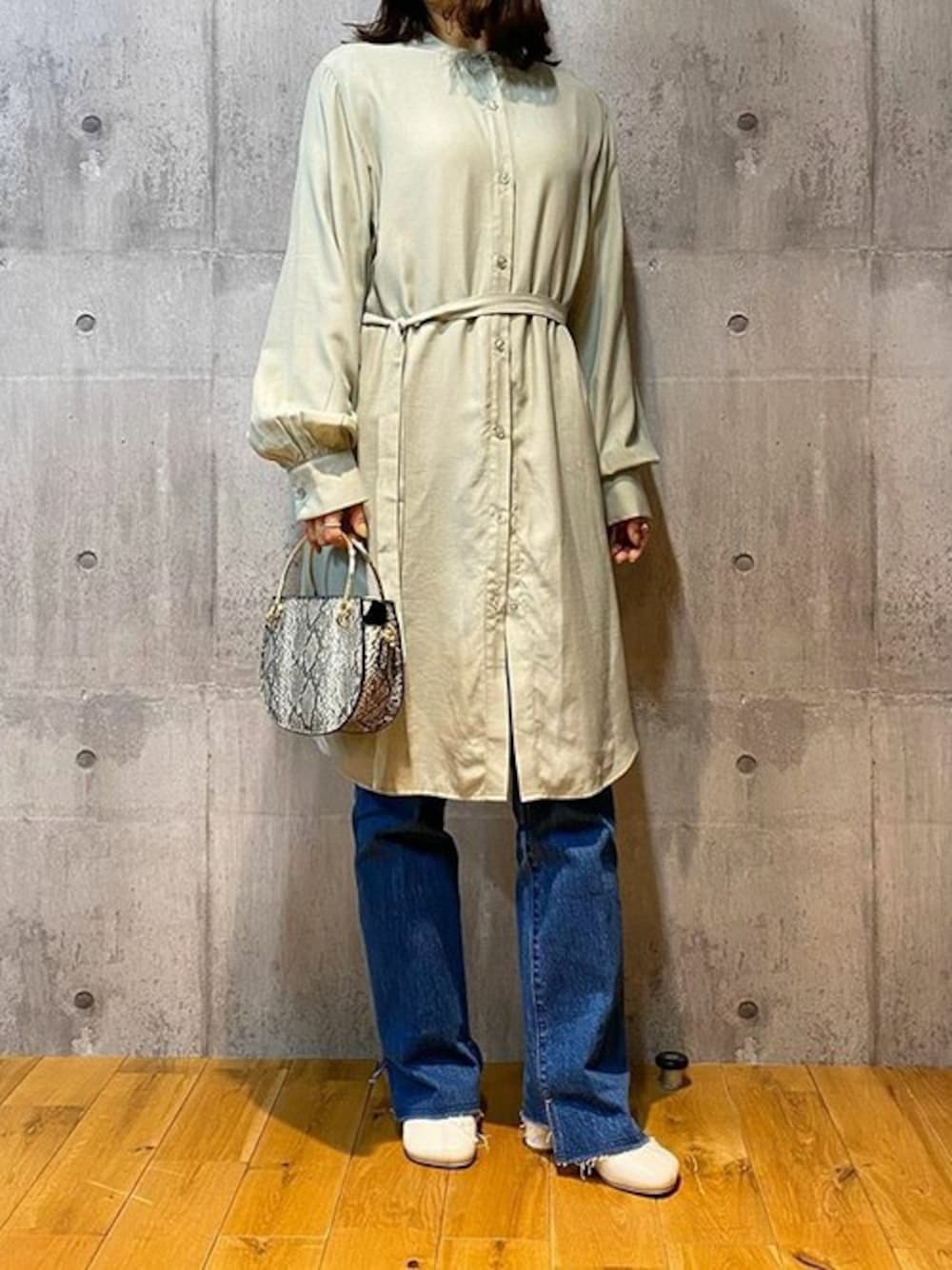 グリーン系のワンピース、ホワイト系のパンプス、その他のハンドバッグを着用したレディースの冬コーディネートの1枚目の写真