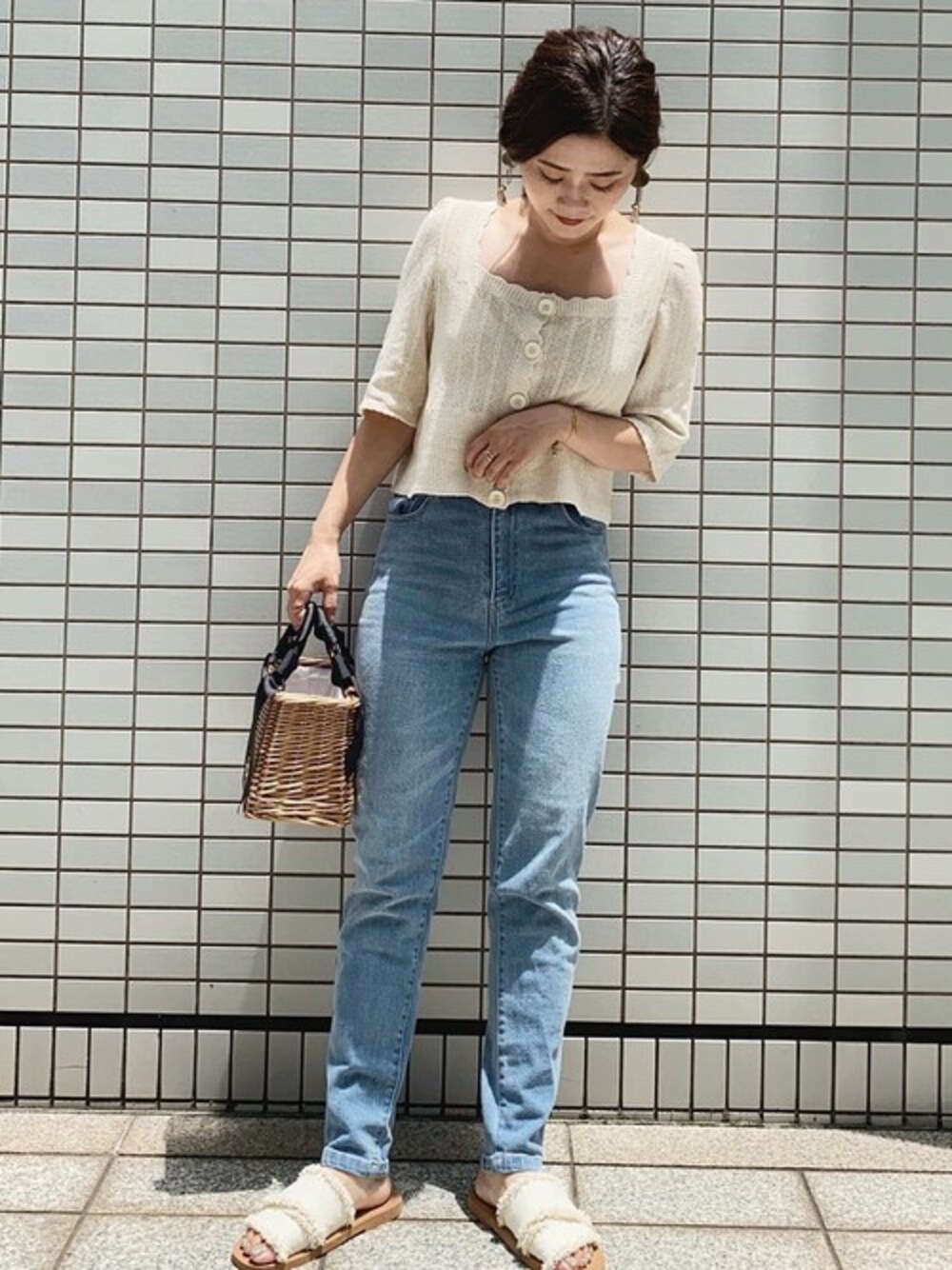 ベージュ系のニット/セーター、ブルー系のデニムパンツ、ホワイト系のサンダルを着用したレディースの夏コーディネートの1枚目の写真