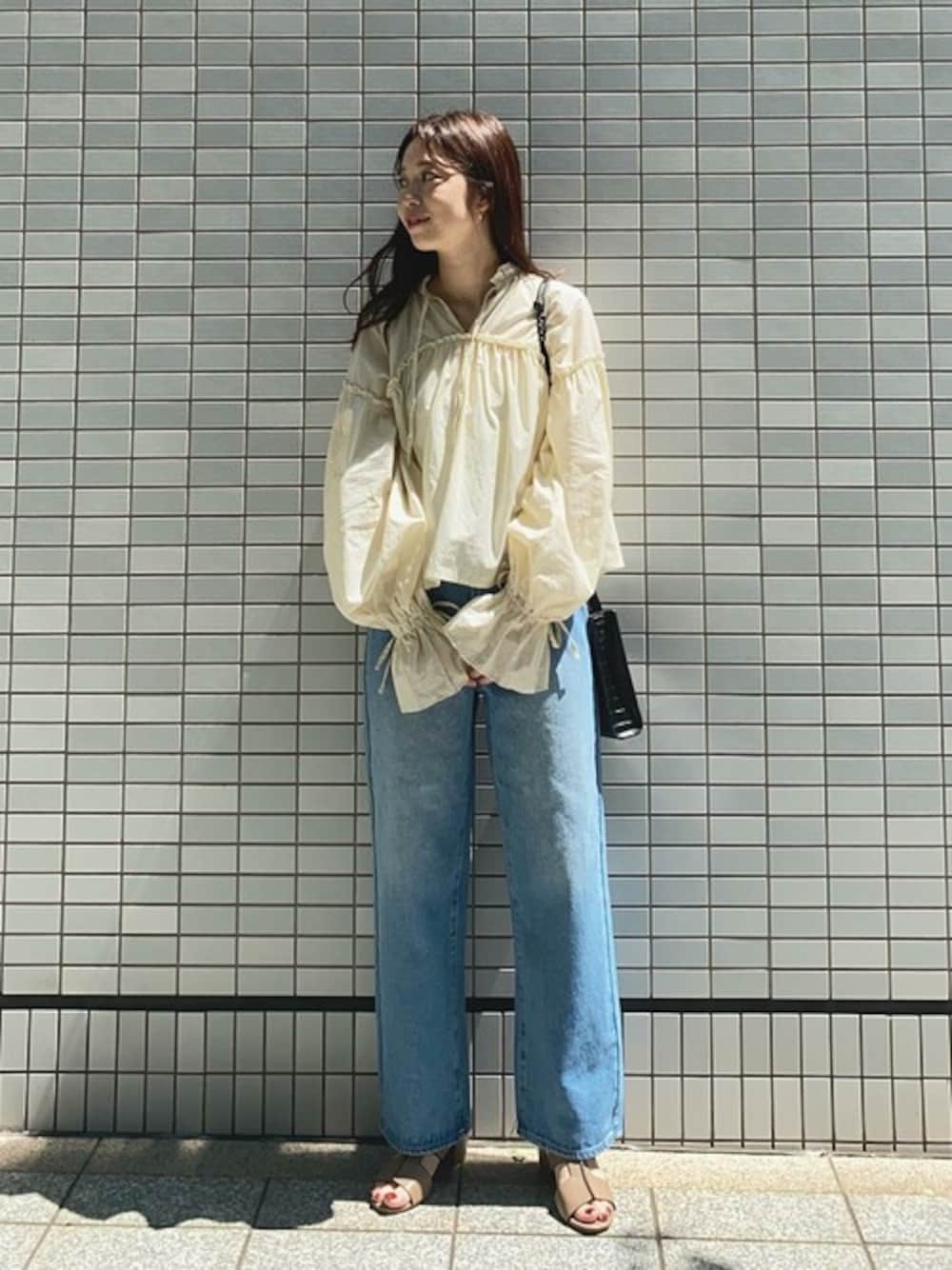 ホワイト系のシャツ/ブラウス、ブルー系のデニムパンツ、ブラウン系のサンダルを着用したレディースの秋コーディネートの1枚目の写真