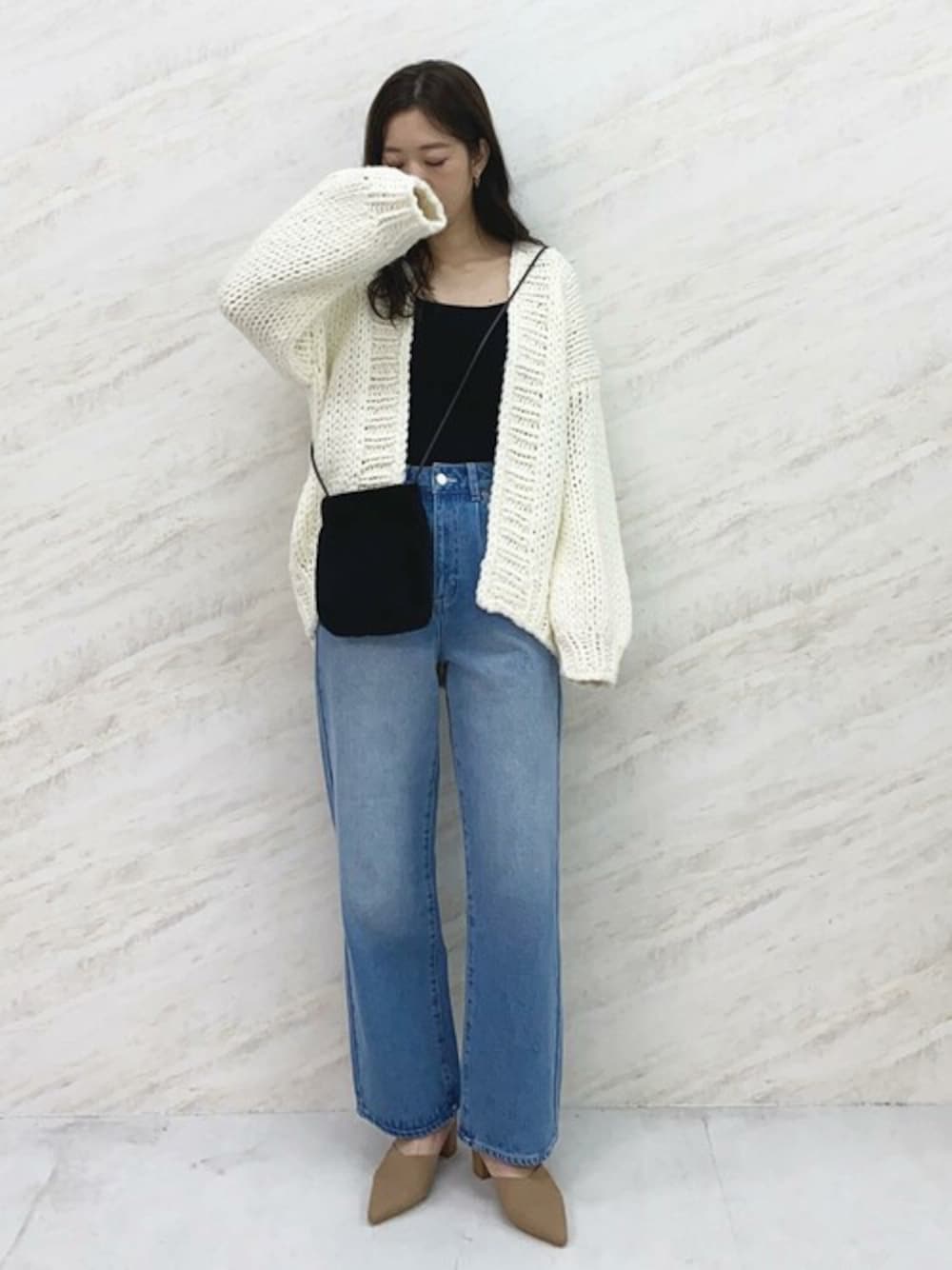 ホワイト系のカーディガン/ボレロ、ブルー系のデニムパンツ、ブラック系のショルダーバッグを着用したレディースの秋コーディネートの1枚目の写真