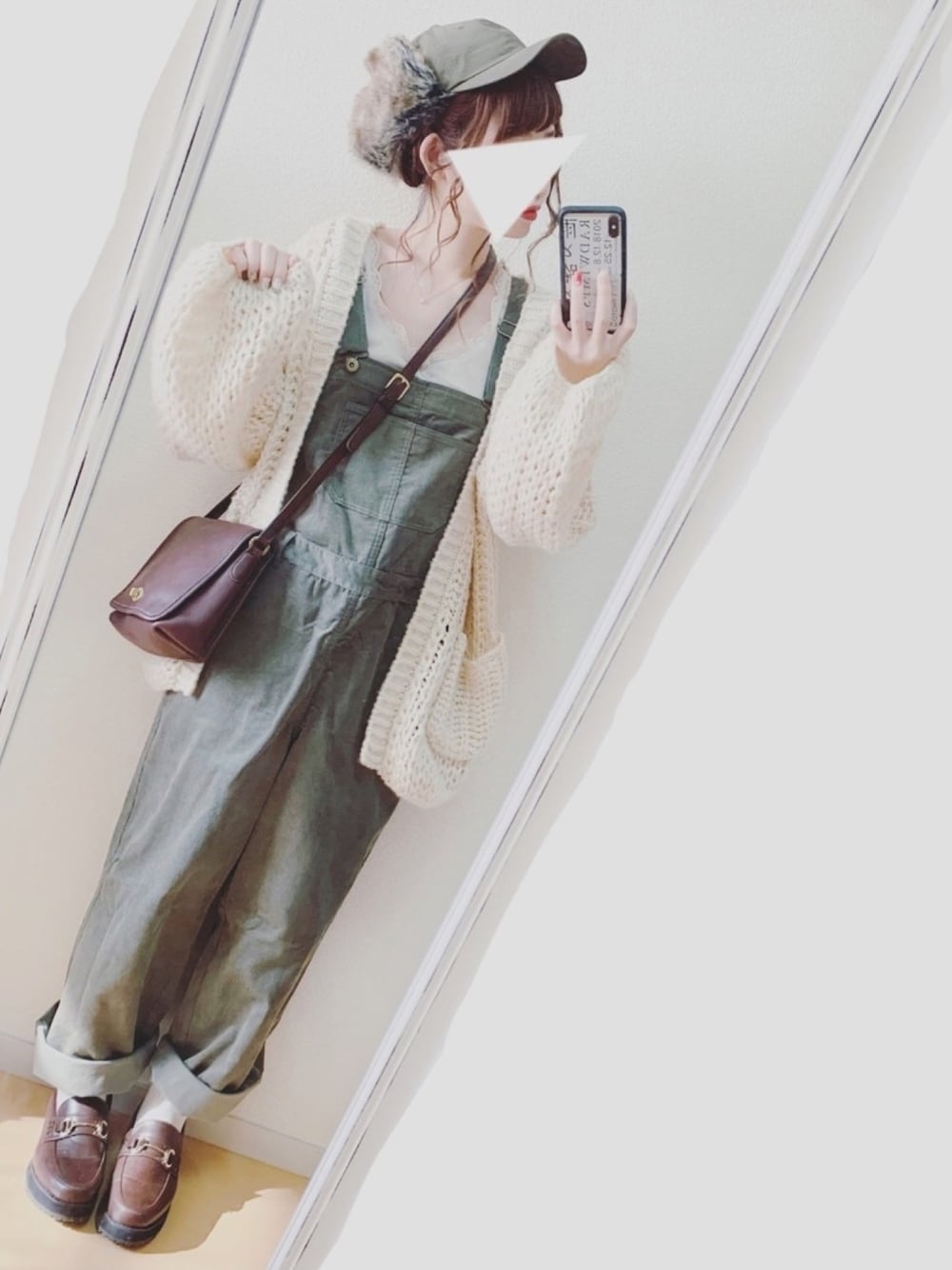 ホワイト系のカーディガン/ボレロ、ブラウン系のローファー、グリーン系のサロペット/オーバーオールを着用したレディースの冬コーディネートの1枚目の写真