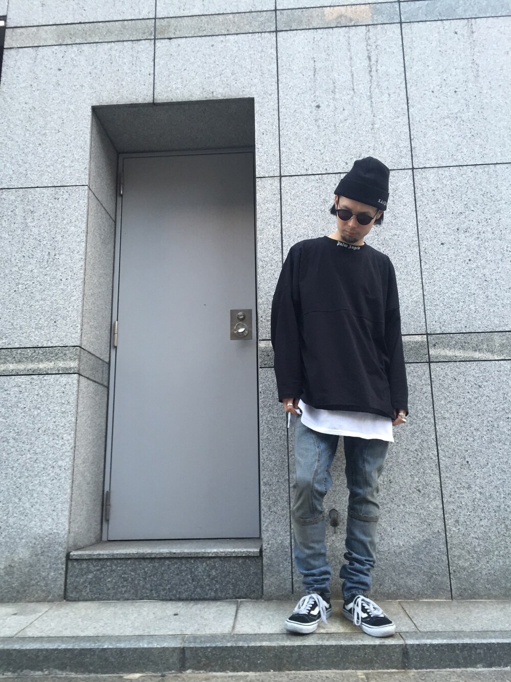 ブラック系のスニーカー、ブルー系のデニムパンツ、ブラック系のTシャツ/カットソーを着用したメンズの冬コーディネートの1枚目の写真