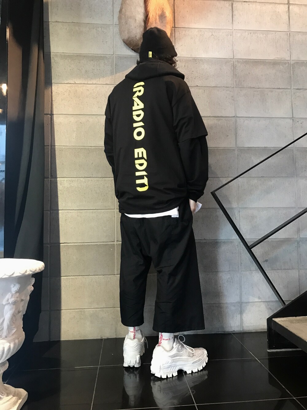 ホワイト系のスニーカー、ブラック系のその他パンツ、ブラック系のTシャツ/カットソーを着用したメンズの春コーディネートの1枚目の写真