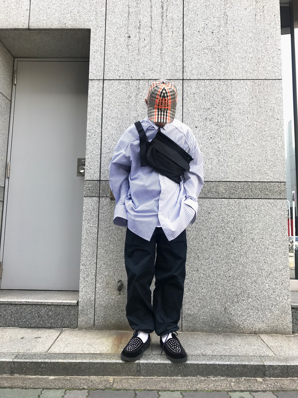 ブラック系のローファー、ブルー系のシャツ/ブラウス、オレンジ系のキャップを着用したメンズの冬コーディネートの1枚目の写真