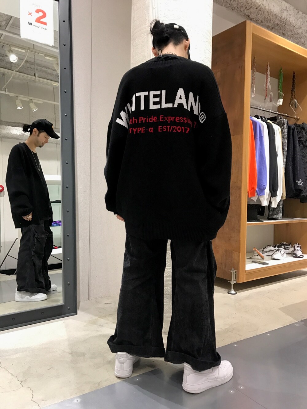 ホワイト系のスニーカー、ブラック系のデニムパンツ、ブラック系のカーディガン/ボレロを着用したメンズの秋コーディネートの1枚目の写真