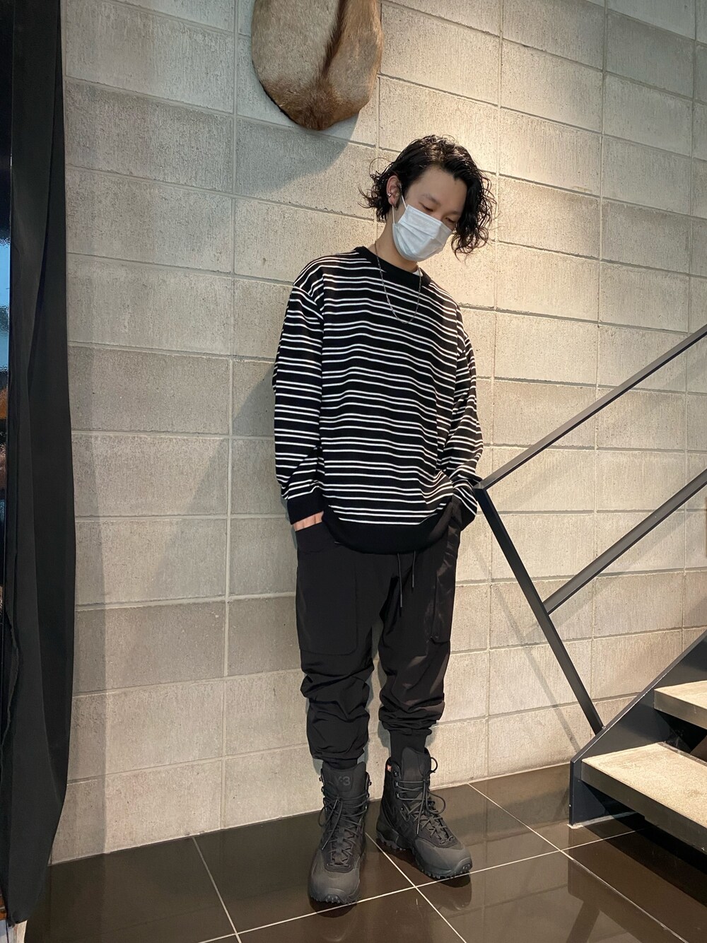 ブラック系のスニーカー、ブラック系のカーゴパンツ、ブラック系のニット/セーターを着用したメンズの冬コーディネートの1枚目の写真