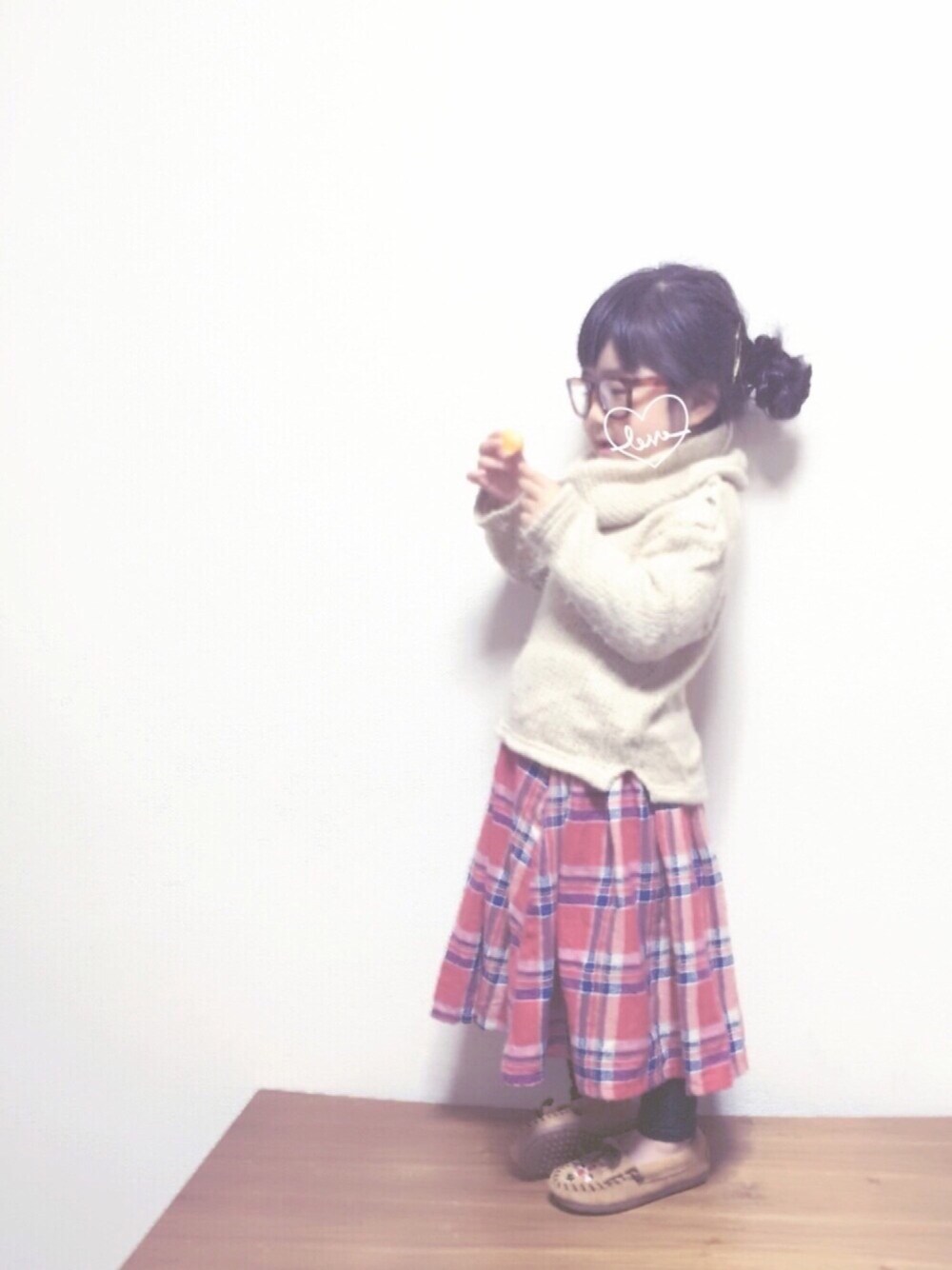 ホワイト系のニット/セーター、レッド系のスカート、ベージュ系のモカシン/デッキシューズを着用したキッズの冬コーディネートの1枚目の写真