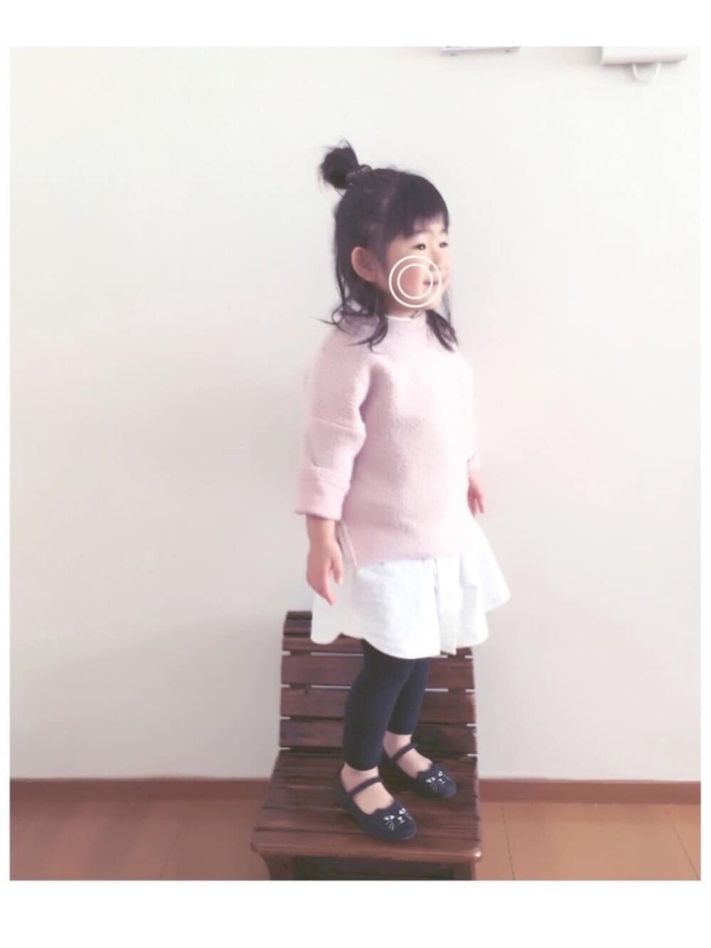 ピンク系のニット/セーター、ホワイト系のシャツワンピース、ブラック系のバレエシューズを着用したキッズの冬コーディネートの1枚目の写真