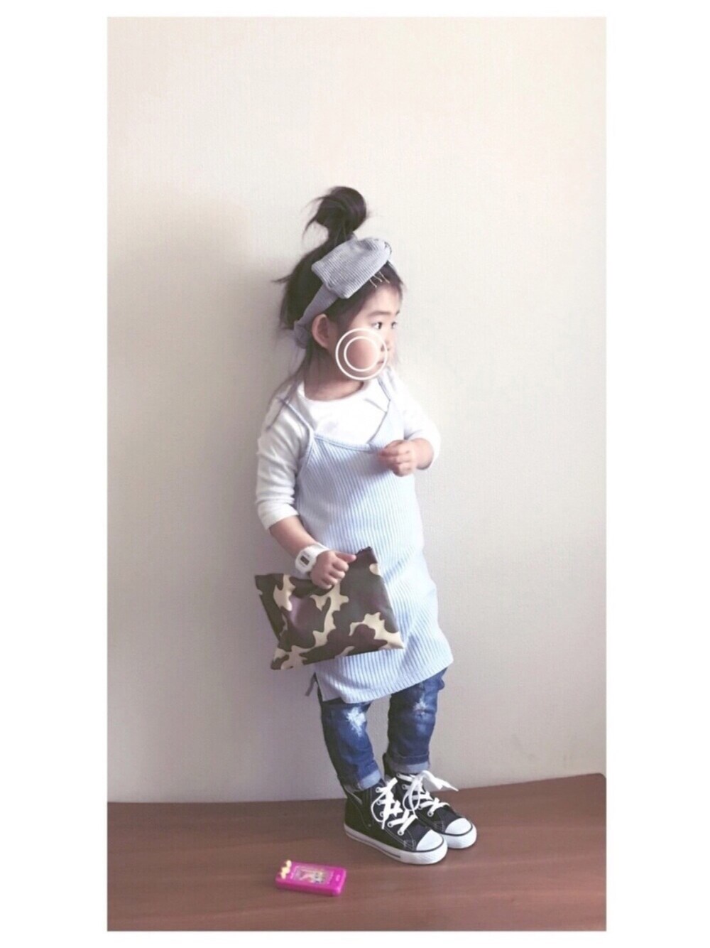 グレー系のワンピース、ブルー系のデニムパンツ、グリーン系のクラッチバッグを着用したキッズの春コーディネートの1枚目の写真