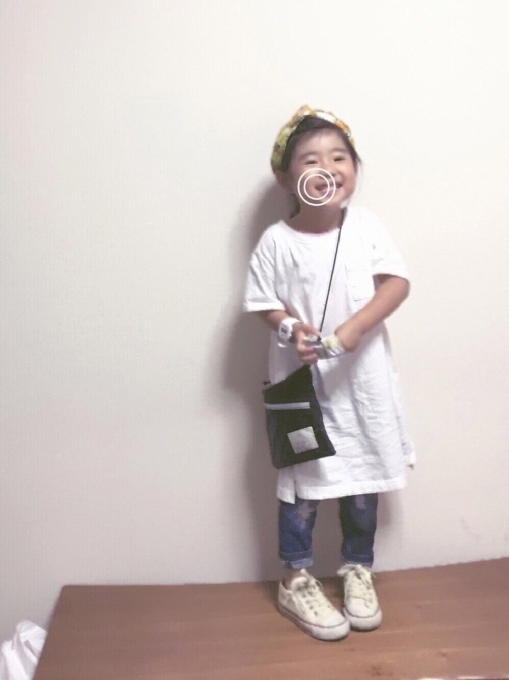 ホワイト系のワンピース、ブラック系のショルダーバッグ、ブルー系のデニムパンツを着用したキッズの夏コーディネートの1枚目の写真