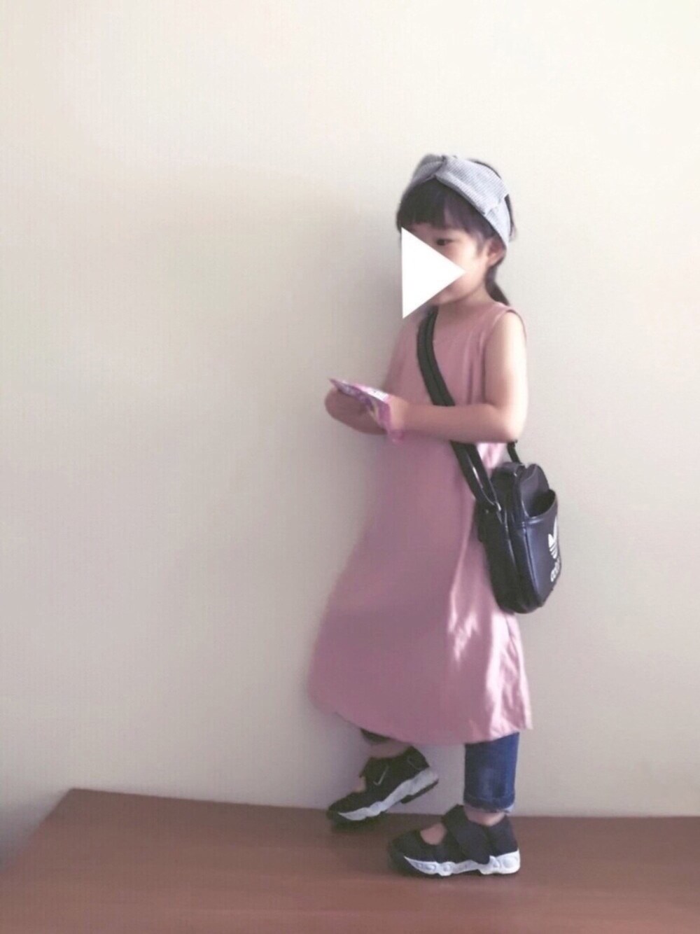 ピンク系のワンピース、ブルー系のデニムパンツ、ブラック系のスニーカーを着用したキッズの夏コーディネートの1枚目の写真