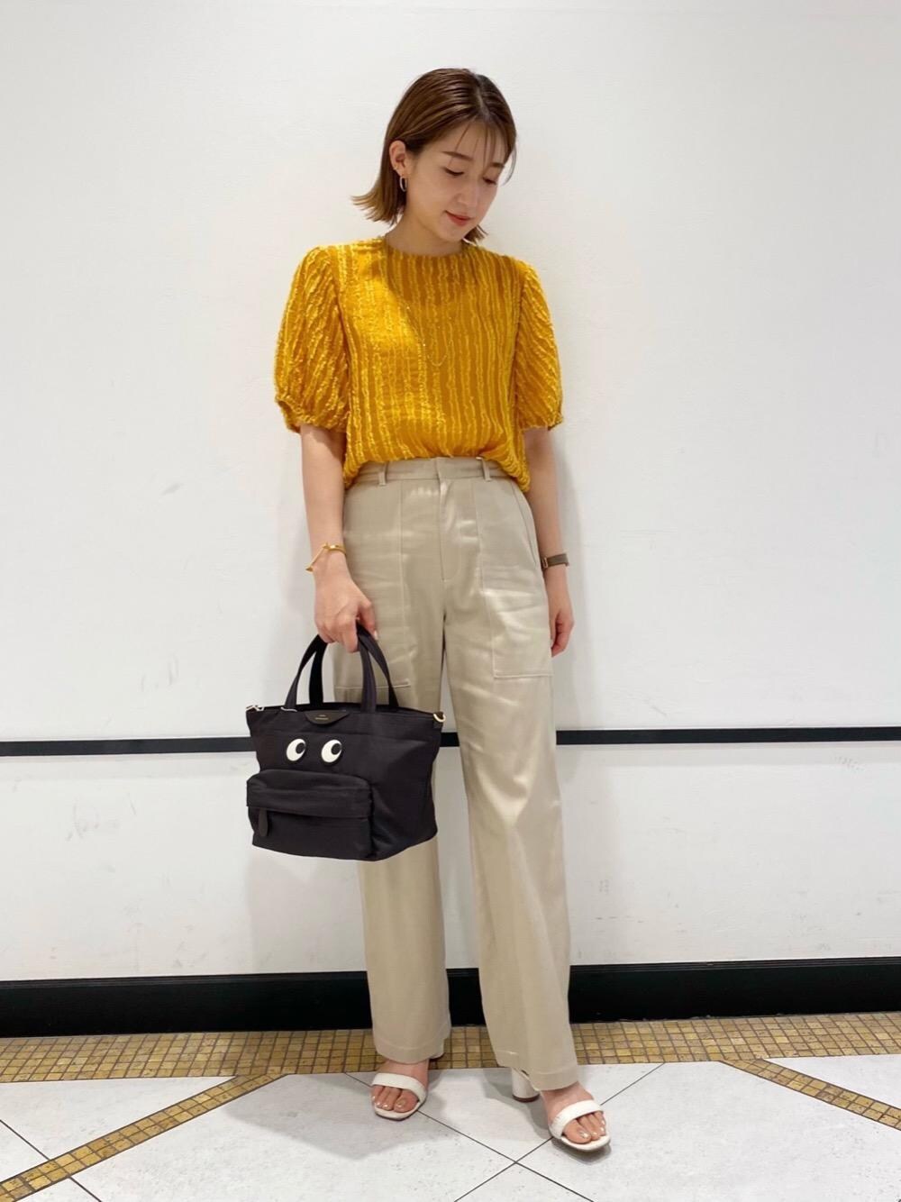 イエロー系のシャツ/ブラウス、ベージュ系のその他パンツ、ゴールド系のネックレスを着用したレディースの夏コーディネートの1枚目の写真