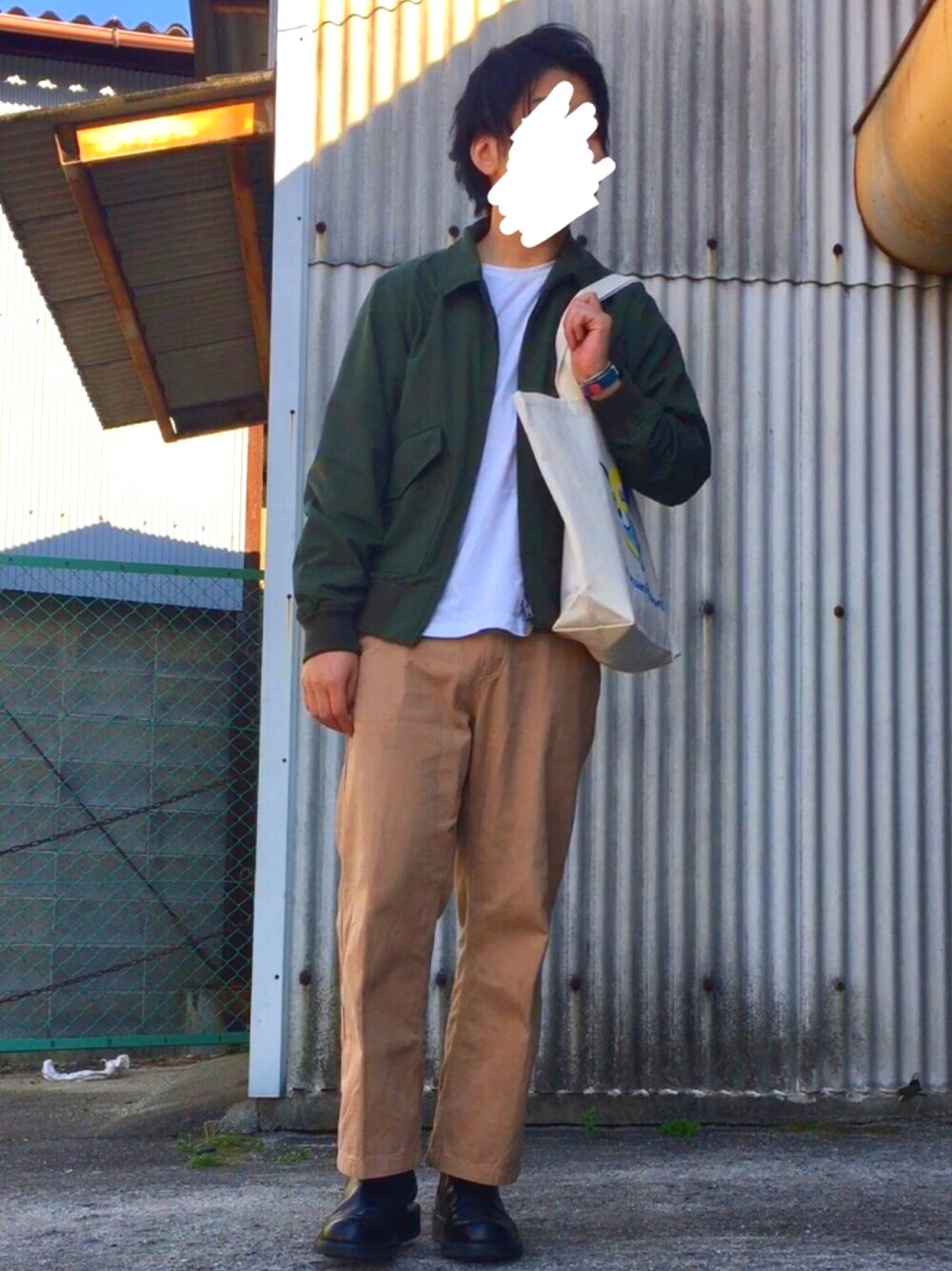 グリーン系のミリタリージャケット、ホワイト系のTシャツ/カットソー、ホワイト系のトートバッグを着用したメンズの春コーディネートの1枚目の写真