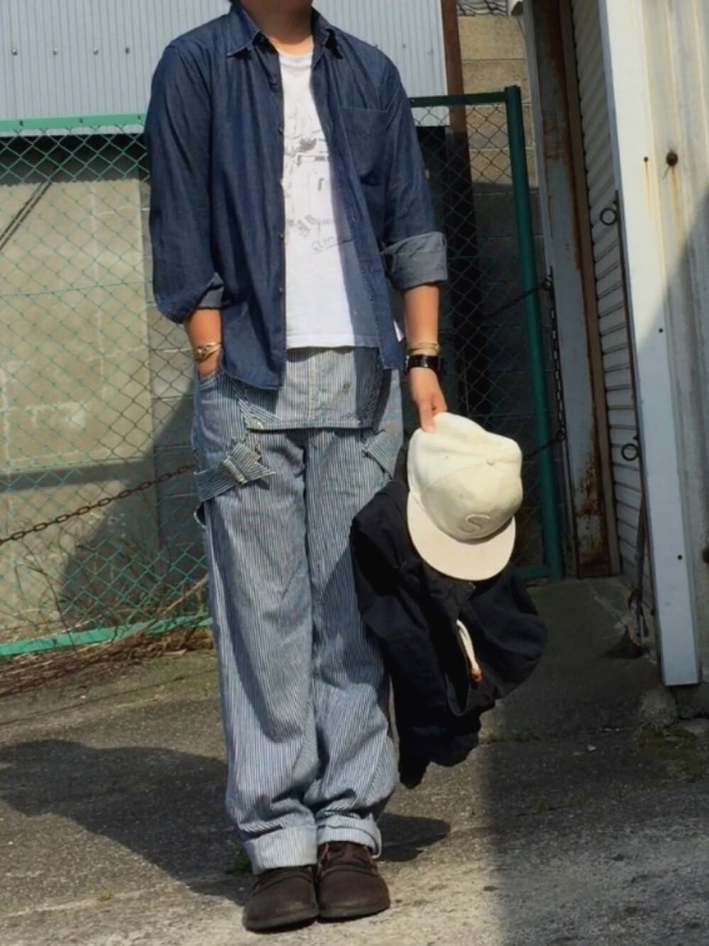 ブルー系のシャツ/ブラウス、ブルー系のサロペット/オーバーオール、ブラック系のブルゾンを着用したメンズの春コーディネートの1枚目の写真