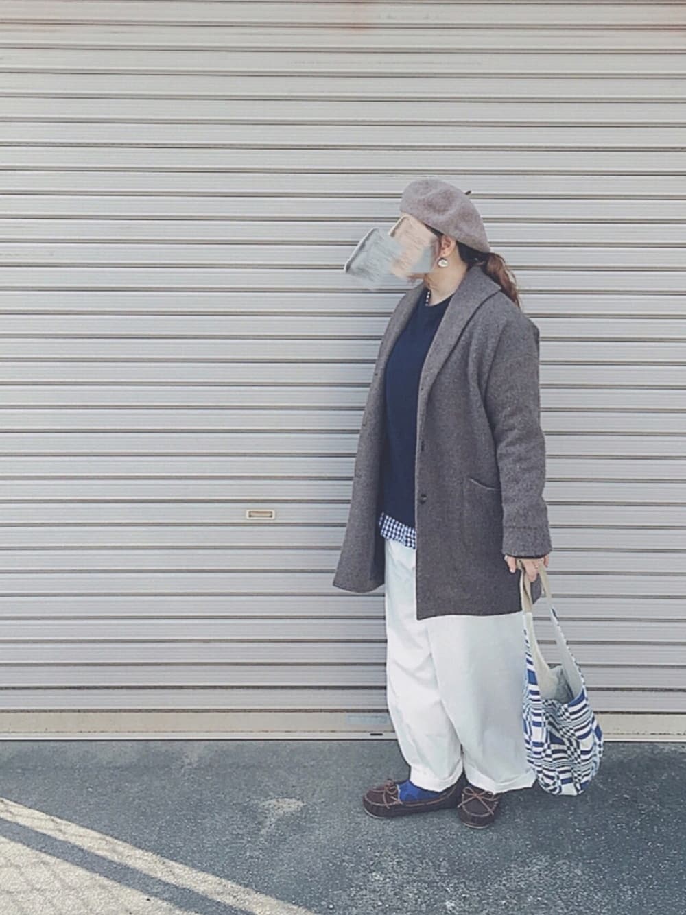 ホワイト系のパンツ、ブルー系のバッグ、ブラウン系のモカシン/デッキシューズを着用したレディースの冬コーディネートの1枚目の写真