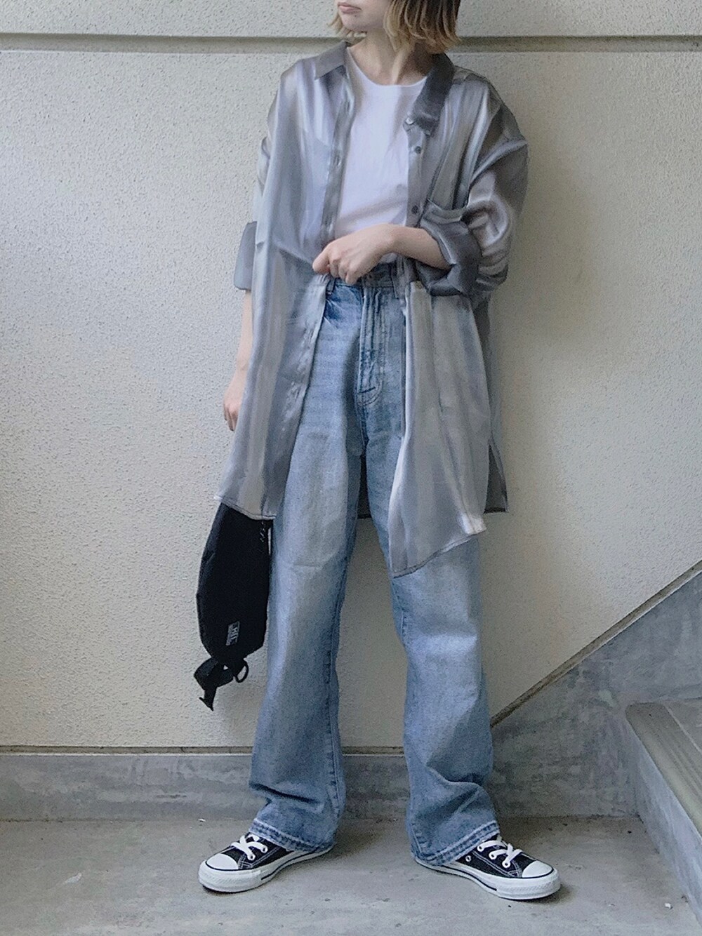 グレー系のシャツ/ブラウス、ブルー系のデニムパンツ、ブラック系のスニーカーを着用したレディースの春コーディネートの1枚目の写真