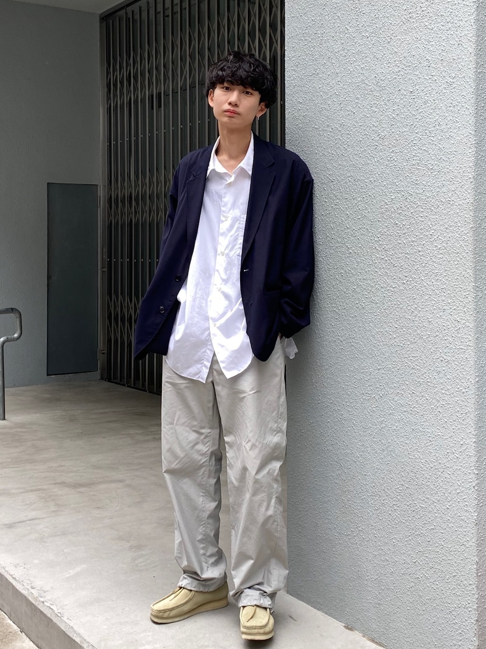 ブルー系のテーラードジャケット、グレー系のパンツ、ベージュ系のモカシン/デッキシューズを着用したメンズの秋コーディネートの1枚目の写真